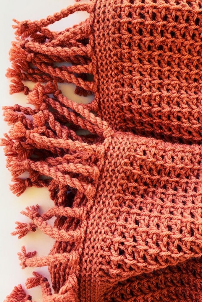 a crochet blanket made with acrylic yarn