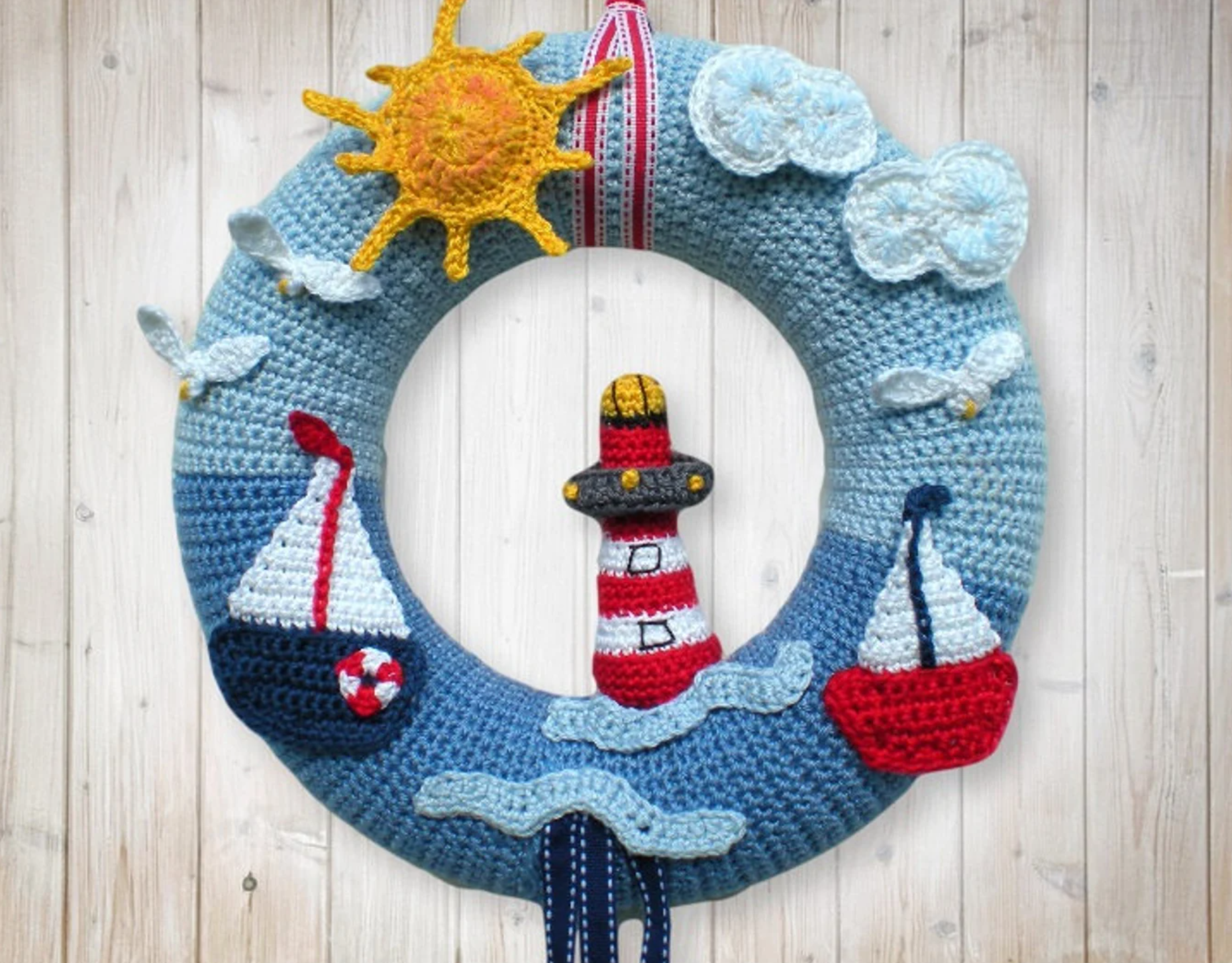 Handcrafted crochet door wreath featuring sailboats, sun and a lighthouse