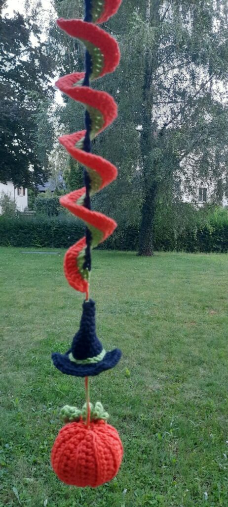 DIY crochet wind spinners in bright yarns spinning on a breezy patio.