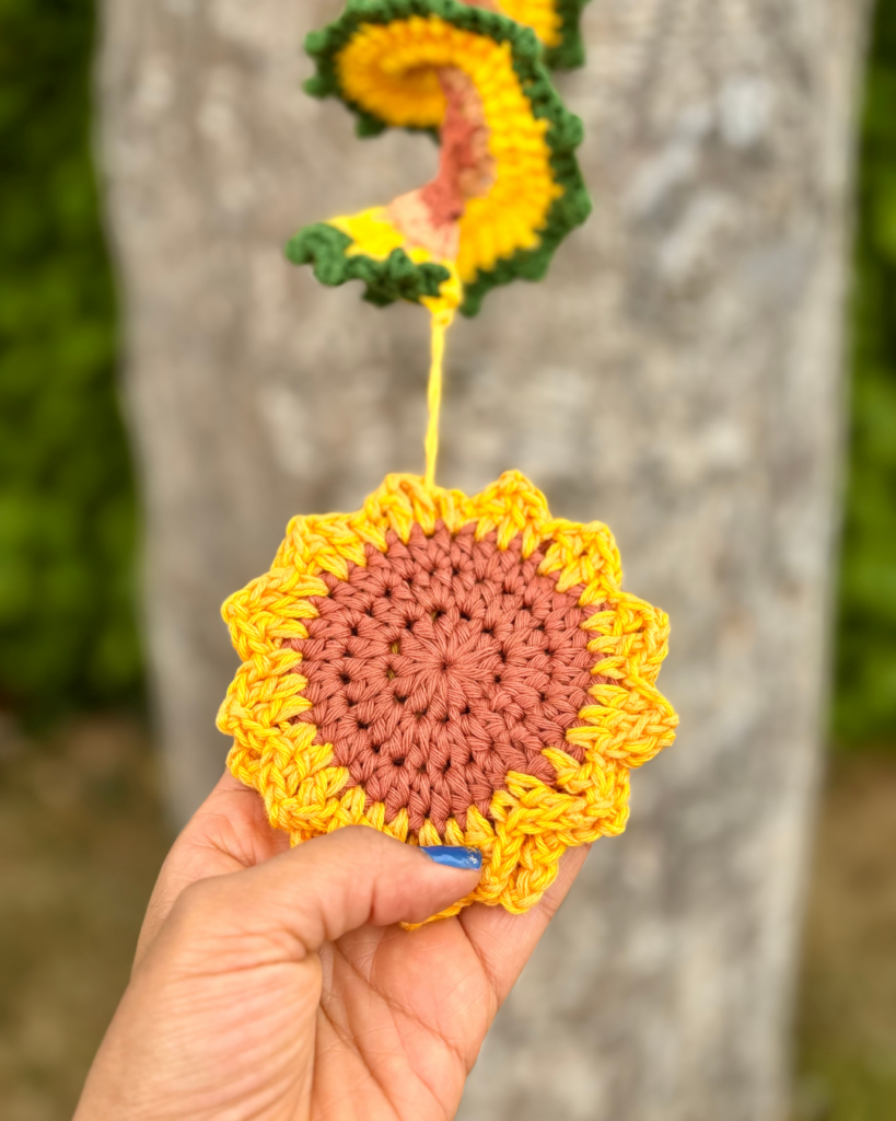 Vibrant crochet wind spinners displayed in a garden, swaying gently in the wind.