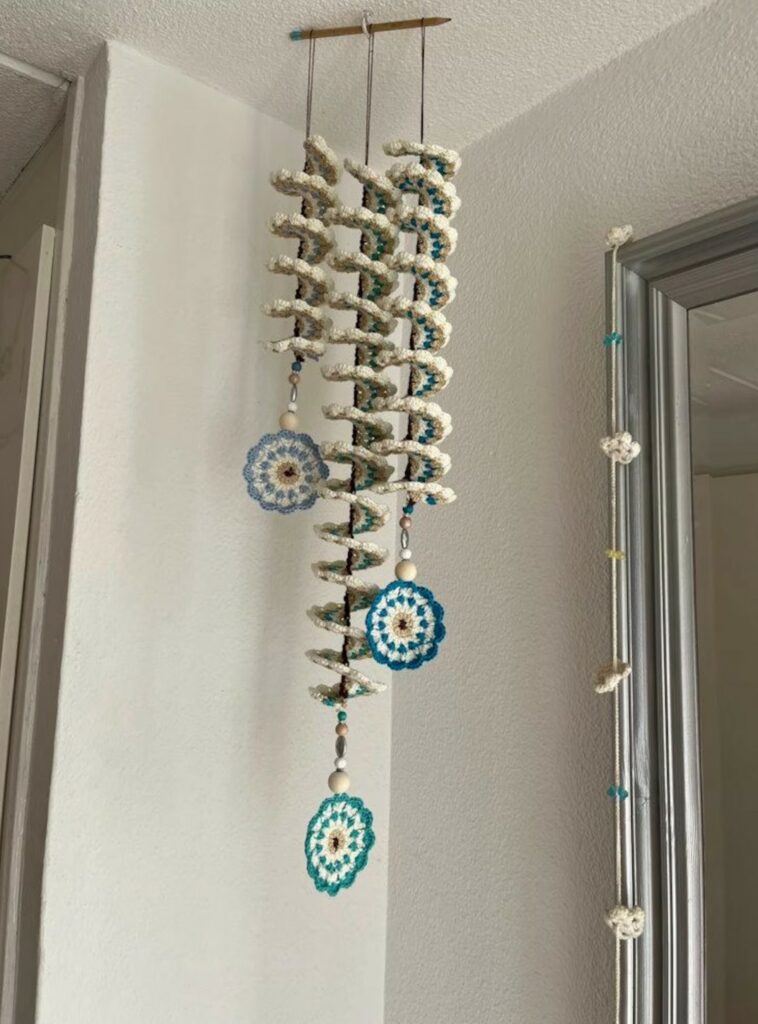 Multiple handmade crochet wind spinners spinning outdoors, showcasing their spiral shapes.