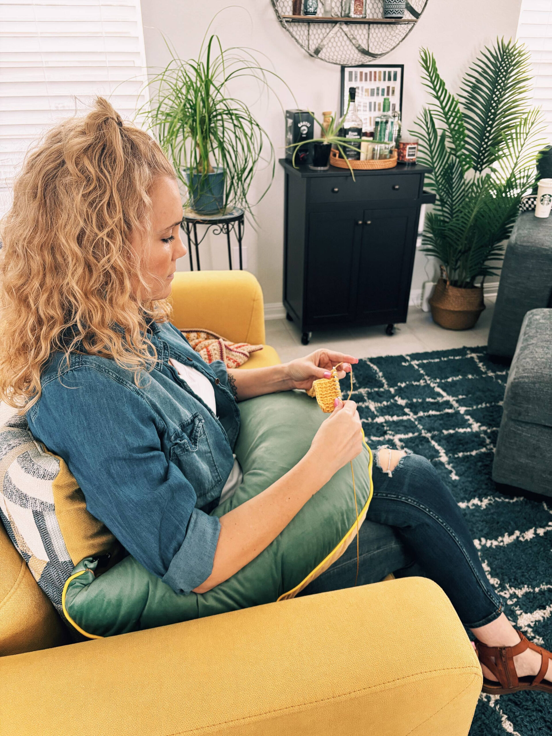 woman using pillow support to help with posture while crocheting