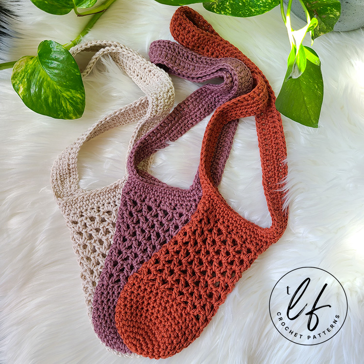 Three crochet market bags in beige, mauve, and rust are displayed on a white textured surface with green plant leaves nearby. This September, discover stylish Crochet Project Ideas for back-to-school essentials. The tlf crochet patterns logo is in the corner.