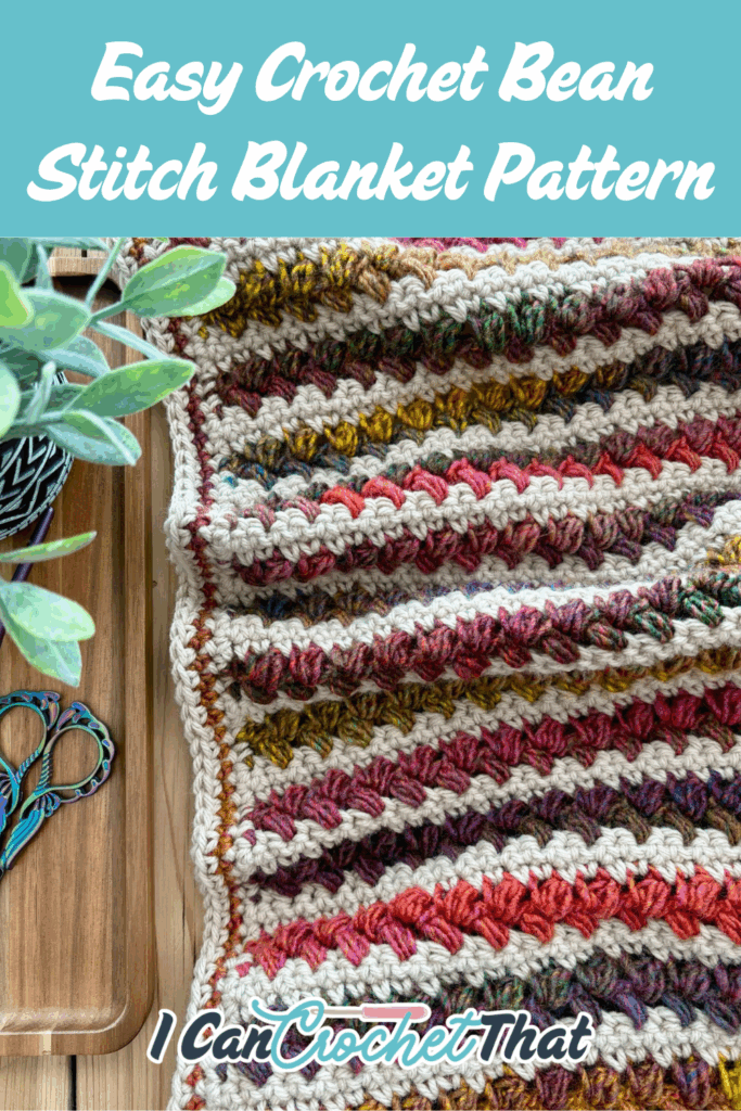 A multicolored easy crochet bean stitch blanket is displayed next to a wooden tray with scissors and a potted plant. Text reads: Easy Crochet Bean Stitch Blanket Pattern.
