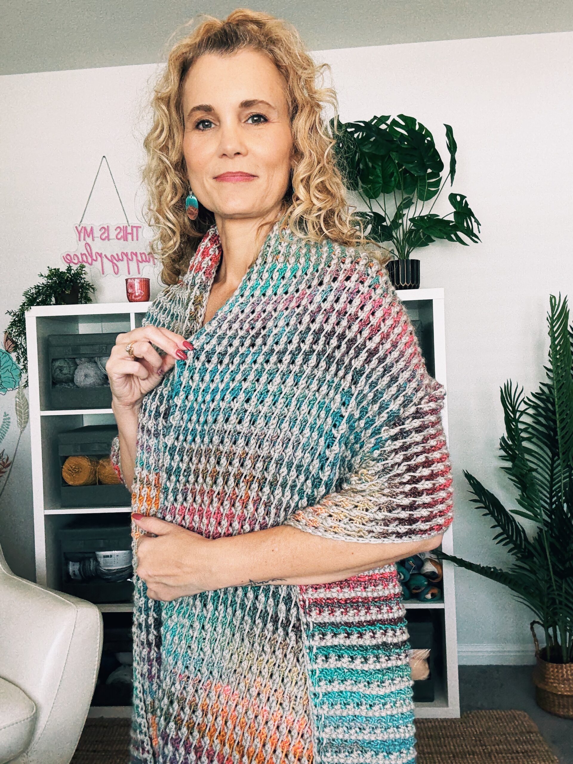 Model wearing Tunisian crochet field stitch blanket scarf wrapped around shoulders.