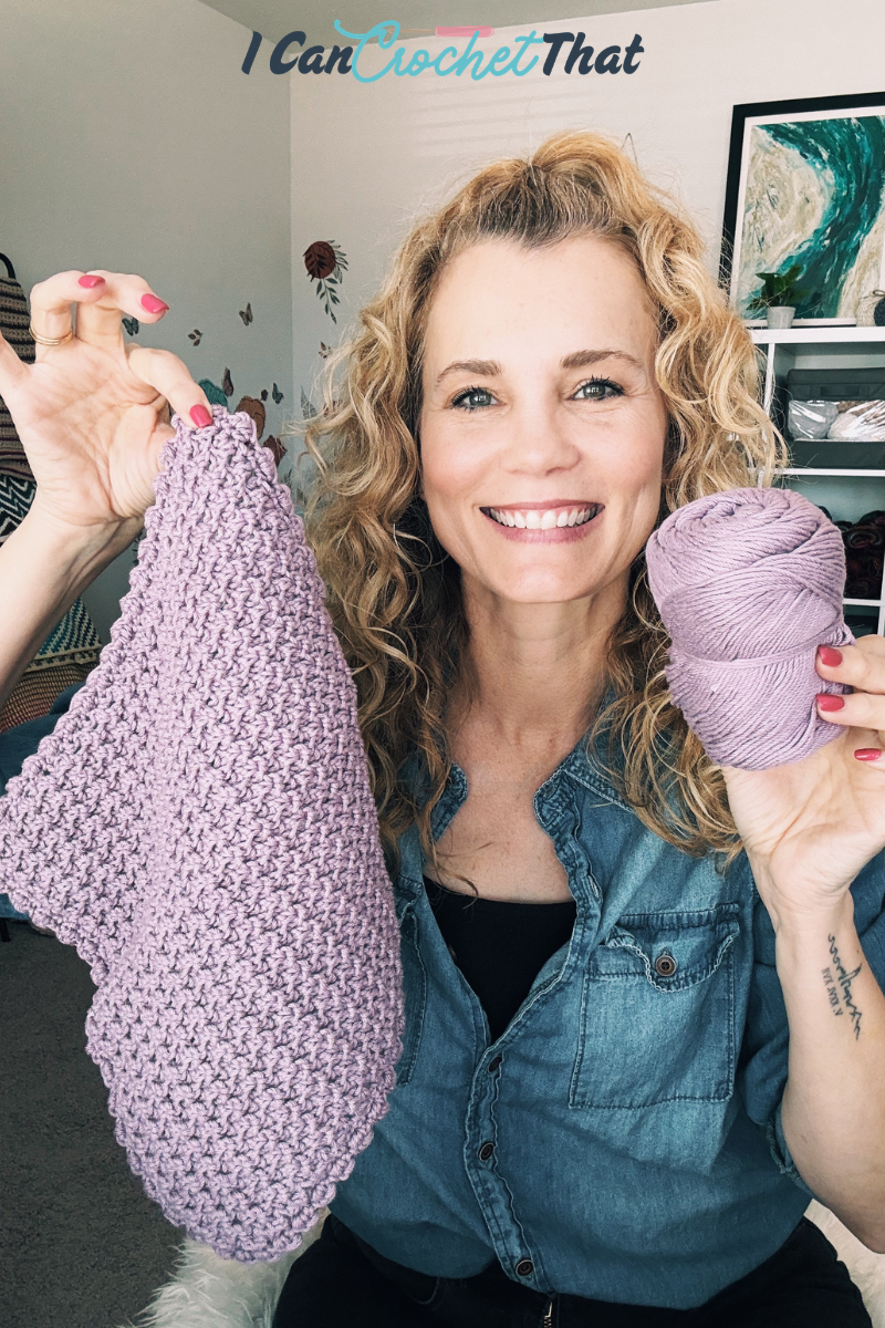 A woman smiles while holding up a crocheted piece and a ball of purple yarn. The text above her reads, I Can Crochet That.